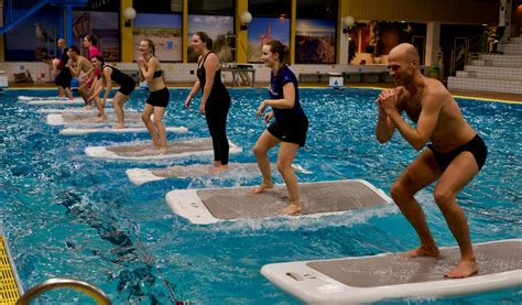Vrouw die aquafitness oefeningen doet met halters