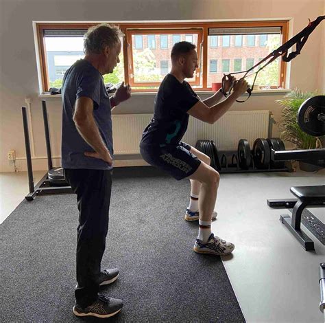 Personal trainer die een oefening voordoet