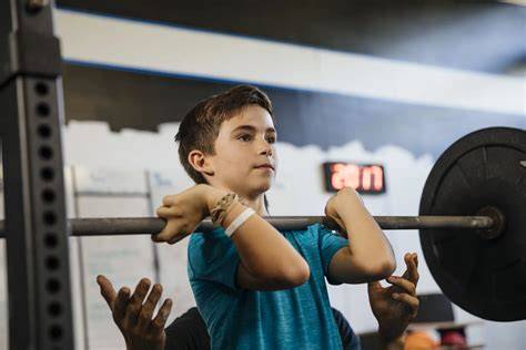 Kind dat aan krachttraining doet onder begeleiding