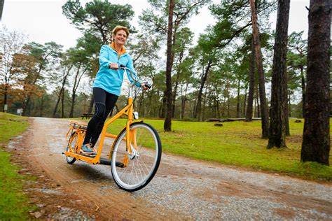 Een persoon die lachend op een Lopifit rijdt in een park