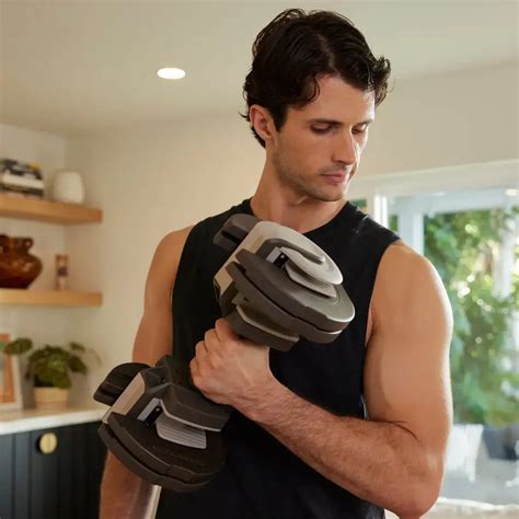 Man traint met verstelbare dumbbells thuis