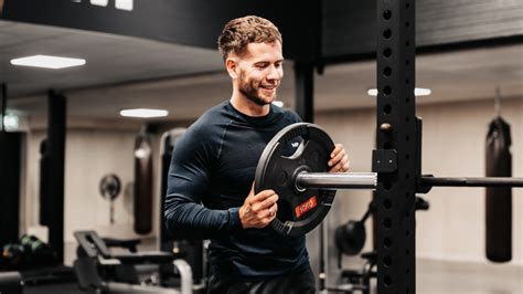 Mens in sportkleding die oefeningen doet met een personal trainer