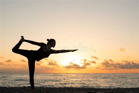 Vrouw die yoga beoefent op het strand