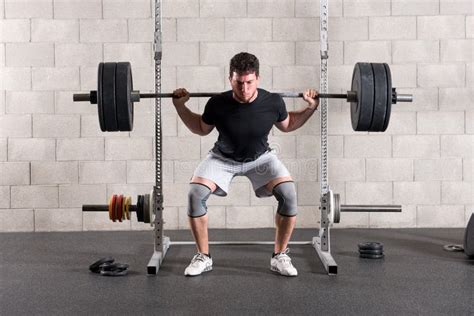 Man die een barbell squat uitvoert