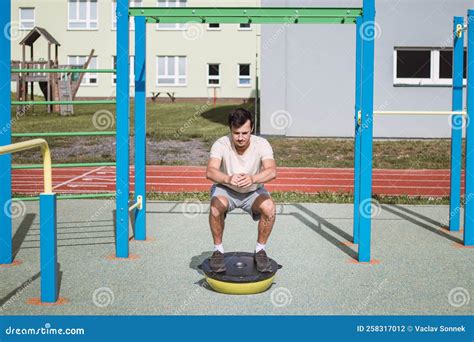 Een atleet voert een front squat uit met een halter op de schouders.
