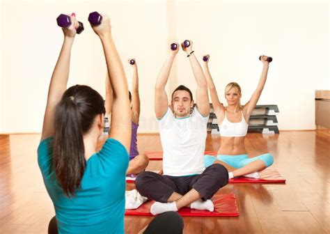 Groep mensen die een fitnessles volgen met een instructeur
