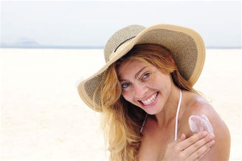 Vrouw smeert zich in met zonnebrandcrème op het strand