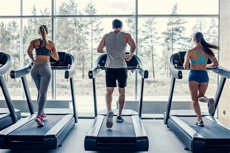 Man en vrouw die samen op loopbanden trainen