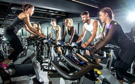 Mensen die cardio-oefeningen doen op apparaten in een sportschool.