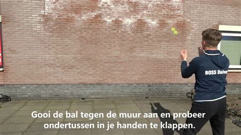 Kind en ouder gooien bal tegen muur