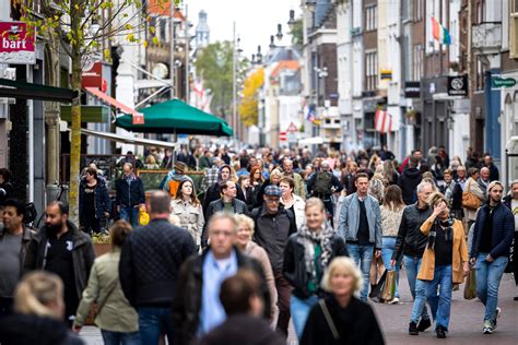 Afbeelding van een drukke fitnesszaal met mensen die wachten bij apparatuur