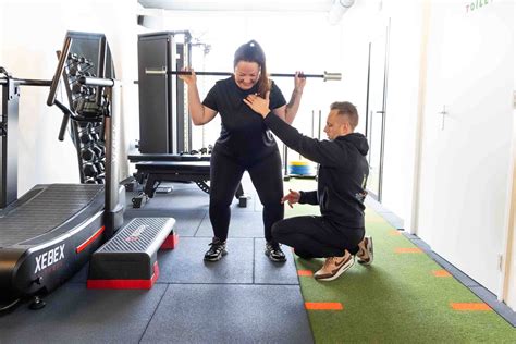 Trainer die een klant instrueert tijdens een personal training sessie
