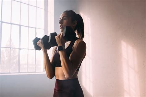 Vrouw doet dumbbell oefeningen thuis