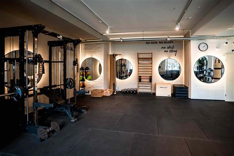 Stijlvolle privé gym met focus op persoonlijke training en comfortabele loungehoek.