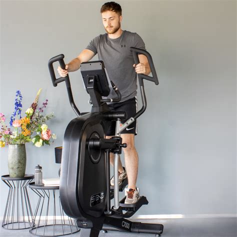 Een persoon die een tablet gebruikt op een crosstrainer