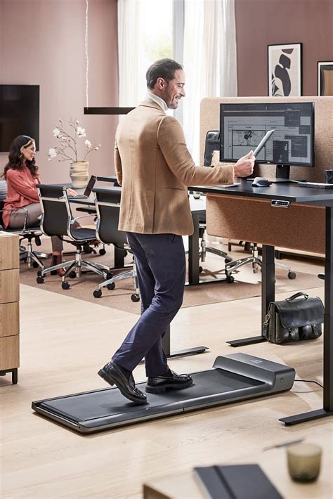 Man die aan een bureau werkt met een loopband eronder