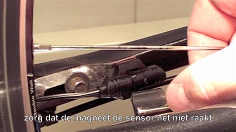 Illustratie van een snelheidssensor en magneet op een loopbandwiel.