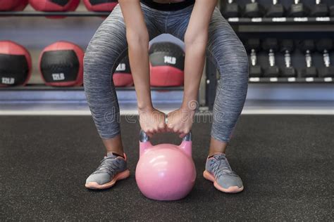 Man die een kettlebell optilt in een fitnessstudio