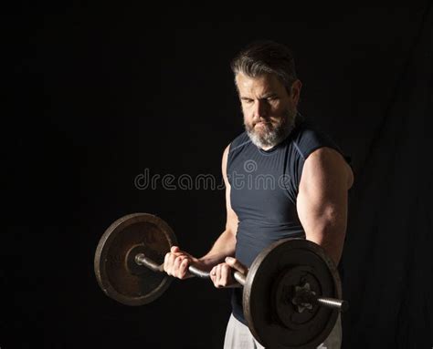 Man van middelbare leeftijd die gewichten heft in de sportschool