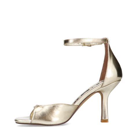 Verschillende soorten gouden sandalen met hak