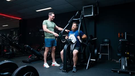 Man en vrouw trainen samen met een personal trainer in een sportschool