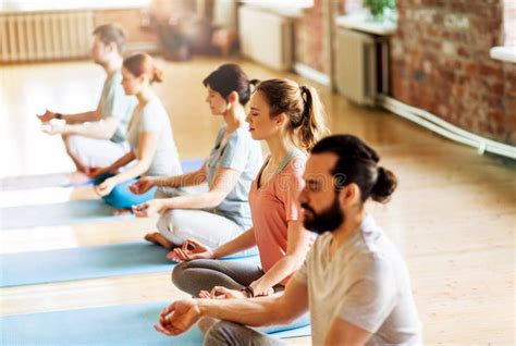 Groep mensen die rustige yoga-oefeningen doen in een lichte studio