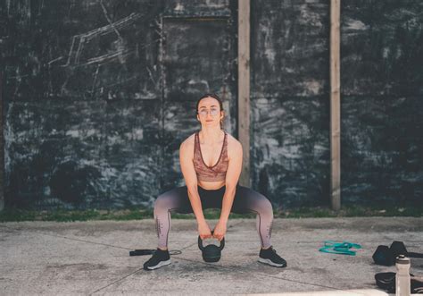 Man die kettlebell oefening uitvoert met armen op 90 graden