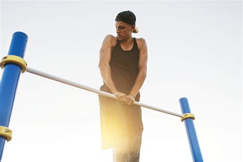 Man die pull-ups doet aan een muurbevestigde bar