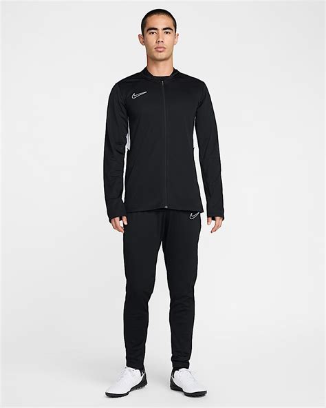 Een man die een Nike Dri-FIT Academy trainingspak draagt tijdens een warming-up.